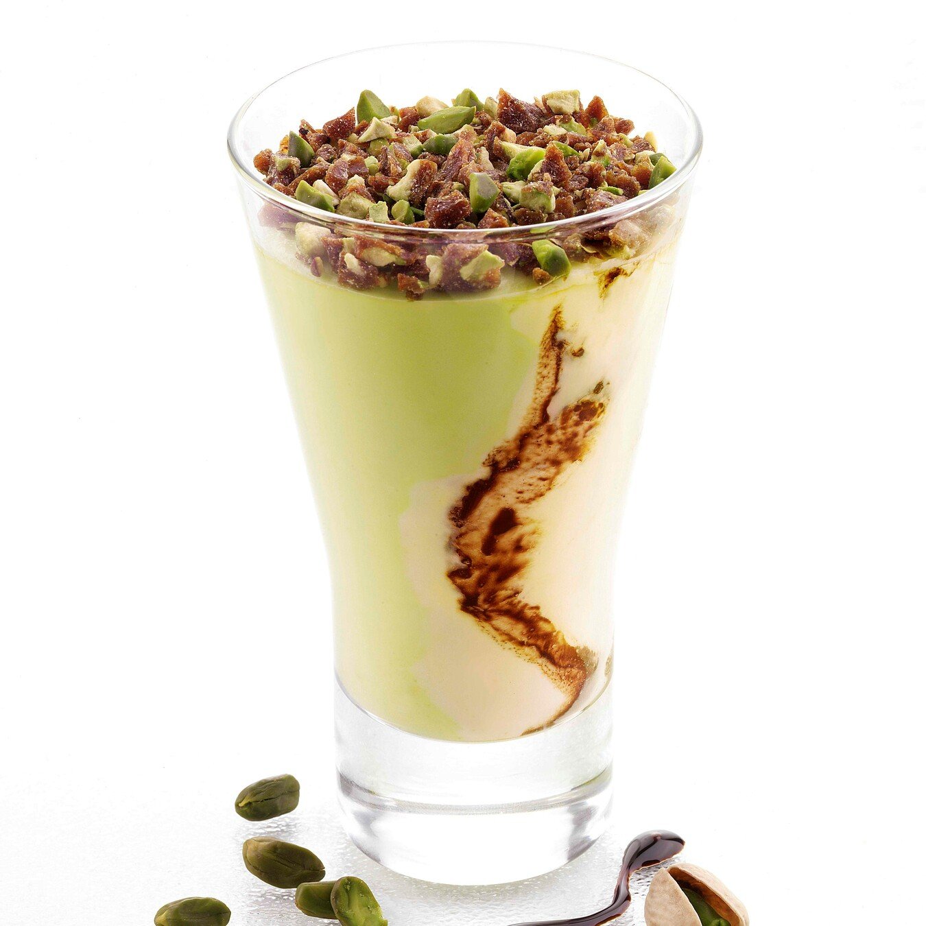 Coppa Gelato Crema e Pistacchio Bindi: un'elegante coppa in vetro con gelato alla crema e al pistacchio variegato al cioccolato, decorata con pistacchi pralinati.