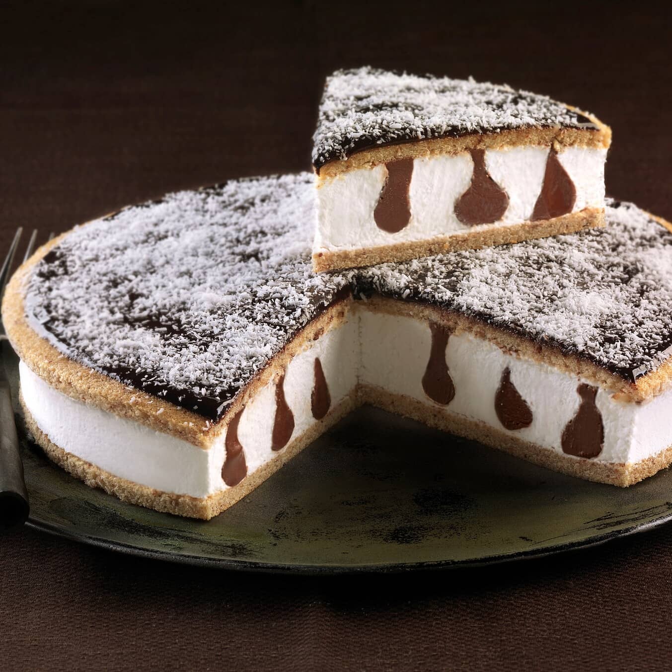 La Torta Cocco Nocciola Bindi è formata da due basi di biscotto alla nocciola farciti con crema al gusto di cocco e crema alla nocciola. Decorata con cocco rapè.